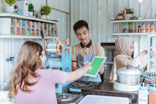 Sumber: https://www.freepik.com/premium-photo/woman-chooses-food-menu-that-seller-brings-small-business-shop_11433019.htm#fromView=search&page=1&position=27&uuid=0bff7553-ec63-43f2-96eb-f464dbf4c03c&query=Saat+Warteg+Menjadi+Guru+Ekonomi+Mikro+Paling+Jujur