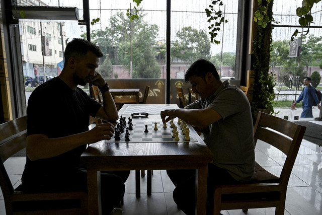 Dua pria memainkan catur di kafe Cupcake Coffee Shop, Kabul, Afganistan, Minggu (11/5/2025). Foto: Wakil Kohsar/AFP