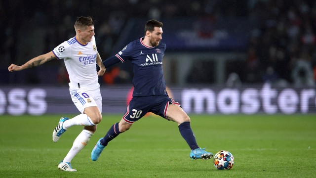 Pemain Paris Saint-Germain (PSG) Lionel Messi berusaha melewati pemain Real Madrid Toni Kroos pada pertandingan 16 besar Liga Champions di Parc des Princes, Paris, Prancis, Rabu (16/2/2022).
 Foto: Sarah Meyssonnier/REUTERS