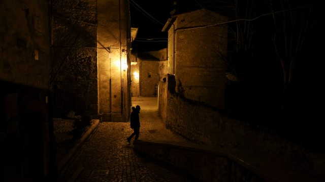 Seorang pria berjalan di sepanjang jalan yang sepi di desa Santo Stefano di Sessanio, Italia, 24 Februari 2022. Foto: Antonio Denti/REUTERS