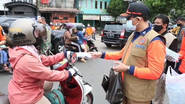 Kepala BNPB Letjen TNI Suharyanto membagikan masker ke warga Kota Cimahi, Minggu (20/2).  Foto: Dok. BNPB