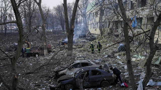 Pekerja darurat Ukraina bekerja di rumah sakit bersalin yang rusak akibat penembakan di Mariupol, Ukraina, Rabu (9/3/2022). Foto: Evgeniy Maloletka/AP Photo