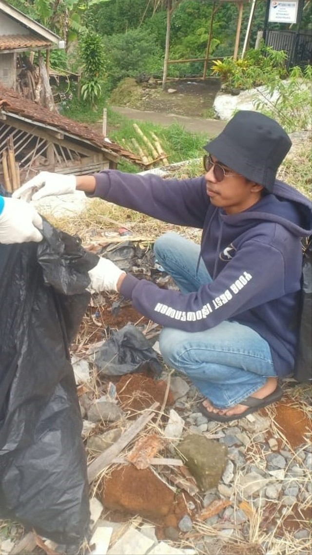 Bagja (berkacamata) sedang mendemonstrasikan pembuatan pupuk kompos (Credit foto: Achmad Bagja AH)