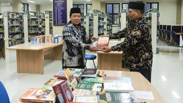 Rektor UIN Ar-Raniry Profesor Warul Walidin AK menerima wakaf 100 buku dari Profesor Syabuddin Gade untuk Perpustakaan UIN Ar-Raniry Banda Aceh, Jumat (8/4). Foto: Nat Riwat