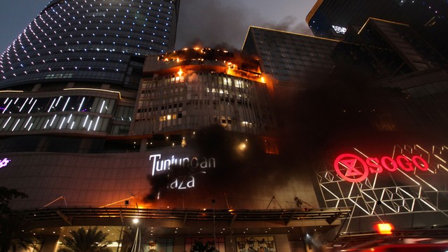 Kobaran api muncul dari Tunjungan Plaza 5 yang terbakar di Surabaya, Jawa Timur, Rabu (13/4/2022). Foto: Didik Suhartono/Antara Foto