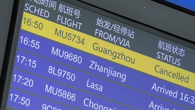 Papan informasi penerbangan menunjukkan penerbangan China Eastern Airlines yang dibatalkan di Bandara Internasional Kunming Changshui di provinsi Yunnan,China, Senin (21/3/2022) Foto: STR/AFP