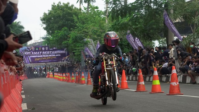 Joki balap memacu kecepatan dan menunjukan skillnya pada Street Race Polda Metro Jaya di Jalan Inspeksi, Ancol Jakarta Utara. Foto: Iqbal Firdaus/kumparan