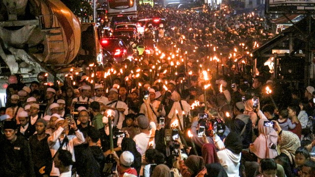 Sejumlah warga mengikuti pawai obor di Jalan Raya Puncak, Kabupaten Bogor, Jawa Barat, Rabu (30/3/2022).
 Foto: Yulius Satria Wijaya/Antara Foto