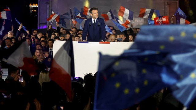 Presiden Prancis Emmanuel Macron berdiri di atas panggung, setelah terpilih kembali sebagai presiden, selama reli kemenangannya di Champ de Mars di Paris, Prancis, Minggu (24/4/2022). Foto: Gonzalo Fuentes/REUTERS