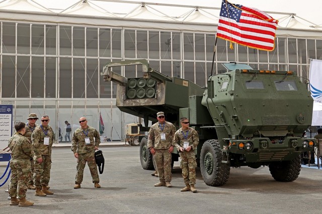 Personel militer AS berdiri di dekat Sistem Roket Artileri Mobilitas Tinggi M142 (HIMARS) di Pameran Pertahanan Dunia pertama Arab Saudi, di utara ibu kota Riyadh, pada Minggu (6/3/2022).
 Foto: Fayez Nureldine/AFP