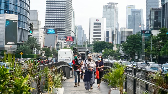 Beberapa warga melewati jembatan penyeberangan di Jakarta pada Rabu (16/3/2022). Foto: Iqbal Firdaus/kumparan