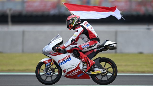 Pembalap Honda Team Asia Mario Suryo Aji membawa bendera merah putih seusai balapan Moto3 seri Pertamina Grand Prix of Indonesia di Pertamina Mandalika International Street Circuit, Lombok Tengah, NTB, Minggu (20/3/2022). Foto: Andika Wahyu/ANTARA FOTO