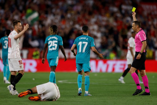 Wasit memberikan kartu kuning kepada pemain Real Madrid Eduardo Camavinga pada pertandingan lanjutan Liga Spanyol di Stadion Ramon Sanchez Pizjuan, Seville, Spanyol. Foto: Marcelo Del Pozo/REUTERS