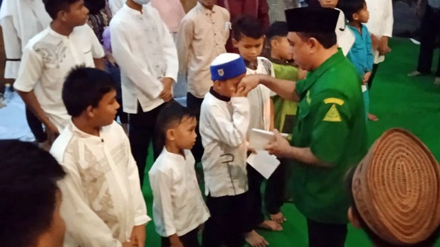 Ketua GP Ansor Sulawesi Utara, Yusra Alhabsy, memberikan santunan untuk anak yatim pada peringatan Hari Lahir GP Ansor ke-88. 