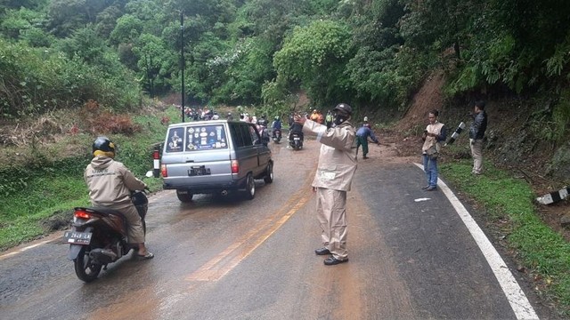 Polisi mengatur arus lalu lintas usai adanya longsor di Jalan Raya Tangkubanparahu-Subang, Kabupaten Subang, Jawa Barat, Senin (2/5/2022). Foto: Dok. Pribadi/Antara