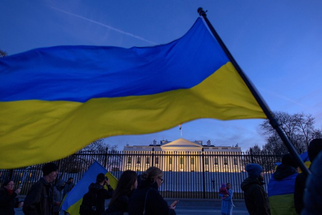 Aktivis memegang bendera Ukraina saat mereka memprotes invasi Rusia ke Ukraina selama rapat umum di Lafayette Square, di seberang Gedung Putih, di Washington, DC pada 25 Februari 2022. Foto: Mandel Ngan/AFP