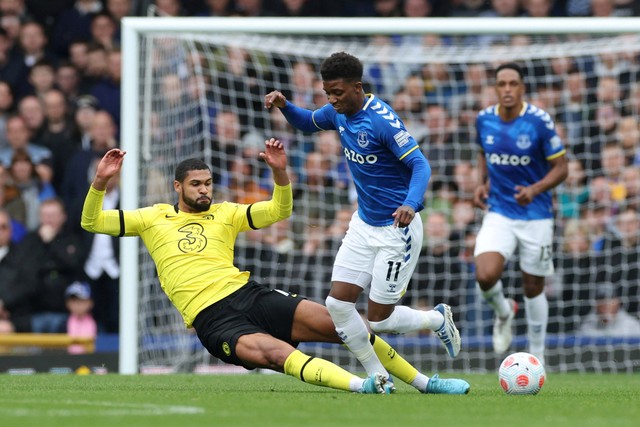 Pemain Everton Demarai Gray berebut bola dengan pemain Chelsea Ruben Loftus-Cheek pada pertandingan lanjutan Liga Inggris 2021/22 di Goodison Park, Liverpool, Inggris. Foto: Phil Noble/REUTERS