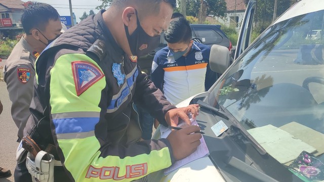 Polisi menilang ambulans Golkar yang hendak terobos one way di Puncak, Sabtu (7/5/2022). Foto: Dok. Istimewa