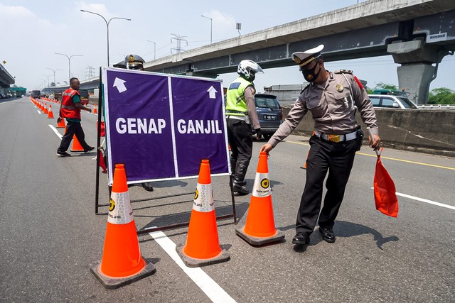 Polisi mengatur arus lalu lintas saat penerapan ganji genap di Tol Cikampek KM 47, Jawa Barat, Senin (25/4).  Foto: Iqbal Firdaus/kumparan