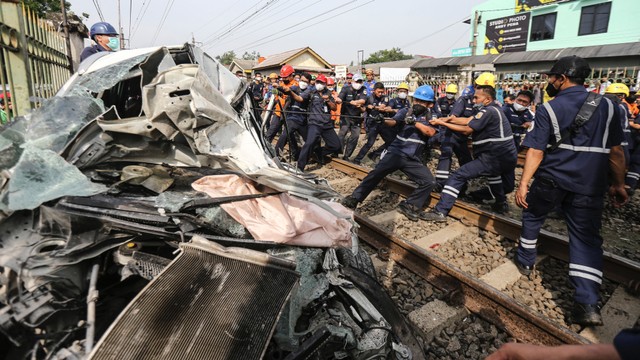 Sejumlah petugas menarik mobil menggunakan tali ketika proses evakuasi di kawasan Rawageni, Cipayung, Depok, Jawa Barat, Rabu (20/4/2022). Foto: Asprilla Dwi Adha/ANTARA FOTO