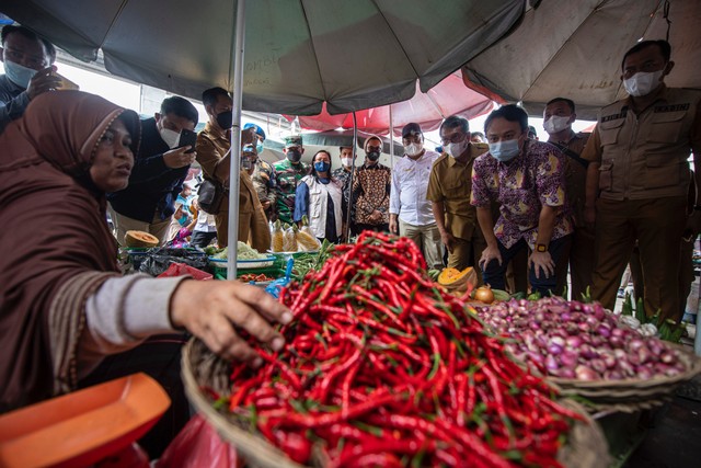 Wakil Menteri Perdagangan Jerry Sambuaga (ketiga kanan) berbincang dengan pedagang saat meninjau ketersediaan barang kebutuhan pokok di Pasar KM 5 Palembang, Sumatera Selatan, Senin (28/3/2022). Foto: Nova Wahyudi/ANTARA FOTO