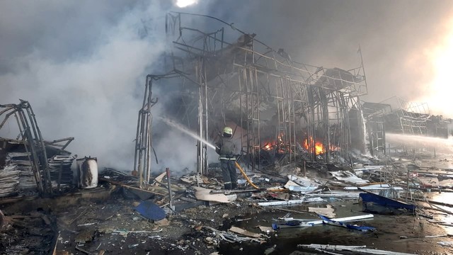 Tim penyelamat bekerja di lokasi gudang penyimpanan produk yang terbakar setelah penembakan, saat serangan Rusia di Ukraina berlanjut, di Kharkiv, Ukraina, Rabu (16/3/2022). Foto: State Emergency Service of Ukraine/Handout via REUTERS