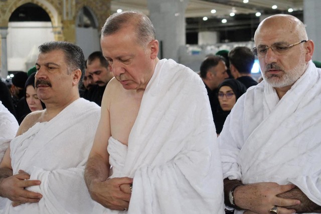 Presiden Turki Erdogan (tengah) bersama pembantunya melaksanakan salat sunah saat umrah di Makkah, Jumat (29/4/2022). Foto: STR/AFP