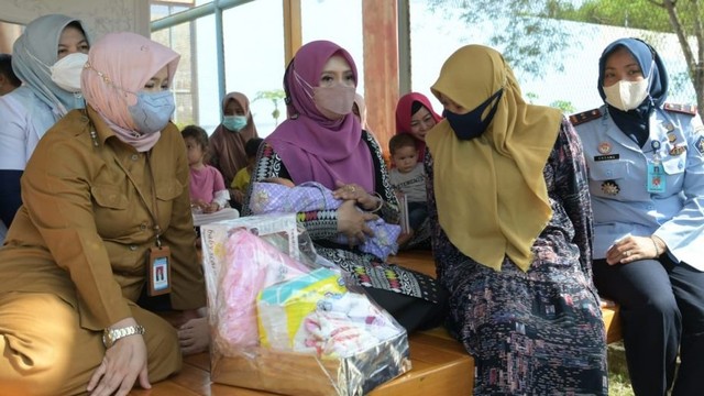 Ketua Badan Kontak Majelis Taklim (BKMT) Aceh,  Dyah Erti Idawati (tengah) menyerahkan bantuan sosial (bansos) untuk warga binaan di Lembaga Pemasyarakatan Perempuan Kelas IIB Sigli, Kabupaten Pidie, Senin (25/4/2022). Foto: Dok. Adpim Setda Aceh