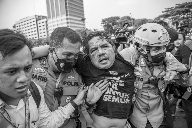 Polisi membawa Ade Armando yang terluka saat demo 11 April di Gedung DPR RI, Jakarta, Senin (11/4/2022). Foto: Aditia Noviansyah/kumparan