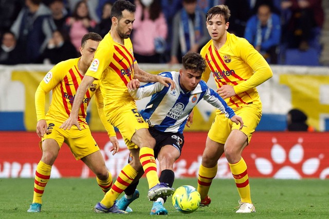 Pemain FC Barcelona Sergio Busquets  berebut bola dengan pemain Espanyol pada pertandingan lanjutan Liga Spanyol di RCDE Stadium, Barcelona, Spanyol.
 Foto: Albert Gea/REUTERS