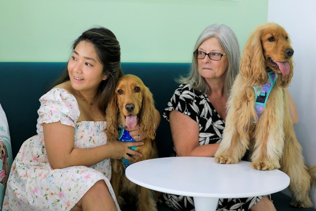 Monica Laine Gonzales-Clark dan Janice Clark duduk bersama anjing mereka di kafe anjing Happy Bark Day, di Dubai, Uni Emirat Arab, Minggu (24/4/2022). Foto: Rula Rouhana/REUTERS