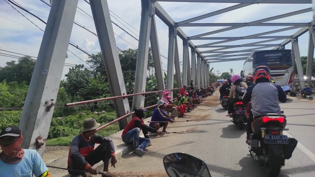 Penyapu koin di sekitar Jembatan Sewo, perbatasan Indramayu-Subang, Jawa Barat, Jumat (6/5/2022). Foto: Agaton Kenshanahan/kumparan