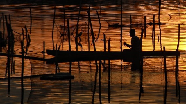 Nelayan di Waduk Lhokseumawe, Aceh beraktivitas saat senja. Foto: Azwar Ipank untuk acehkini