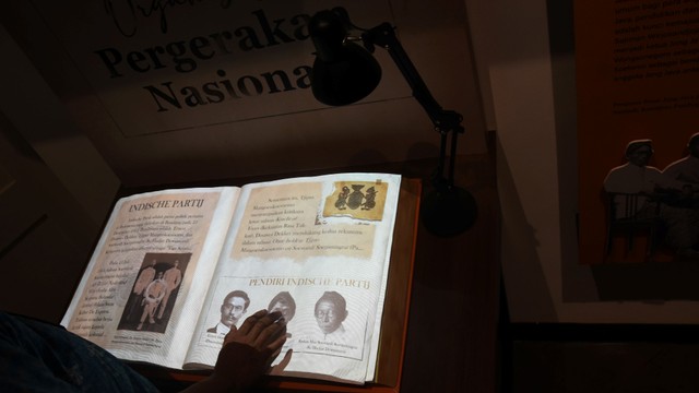 Petugas museum menunjukkan buku sejarah terbentuknya Sumpah Pemuda yang telah diarsipkan ke dalam format digital di Museum Sumpah Pemuda, Kramat, Jakarta, Selasa (22/3/2022). Foto: Indrianto Eko Suwarso/Antara Foto