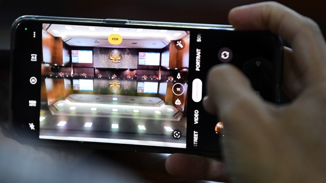 Jurnalis memotret jalannya sidang pembacaan putusan Pengujian Materiil Undang-Undang Nomor 7 Tahun 2017 tentang Pemilihan Umum di Gedung Mahkamah Konstitusi, Jakarta, Rabu (20/4/2022). Foto: Sigid Kurniawan/ANTARA FOTO