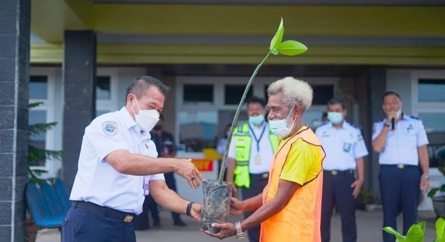 Kepala Kantor UPBU Kelas 1 Domine Eduard Osok Sorong Cece Tarya menyerahkan anakan mangrove secara simbolis kepada salah satu warga yang ikut dalam program padat karya Bandara DEO Sorong, foto: Yanti/Balleo News
