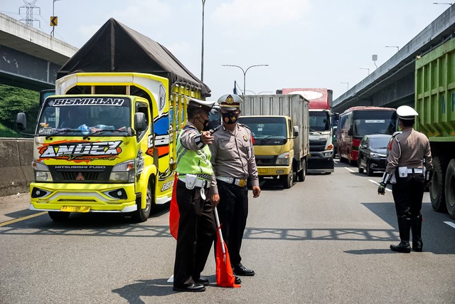 Polisi mengatur arus lalu lintas saat penerapan ganjil genap di Tol Cikampek KM 47, Jawa Barat, Senin (25/4).  Foto: Iqbal Firdaus/kumparan