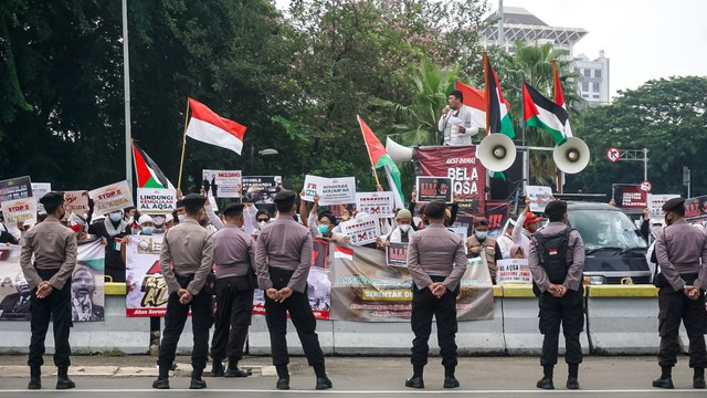 Petugas kepolisian berjaga saat Aksi Bela Al-Aqsa di Jalan Medan Merdeka Selatan, Jakarta pada Rabu (20/4/2022). Foto: Iqbal Firdaus/kumparan