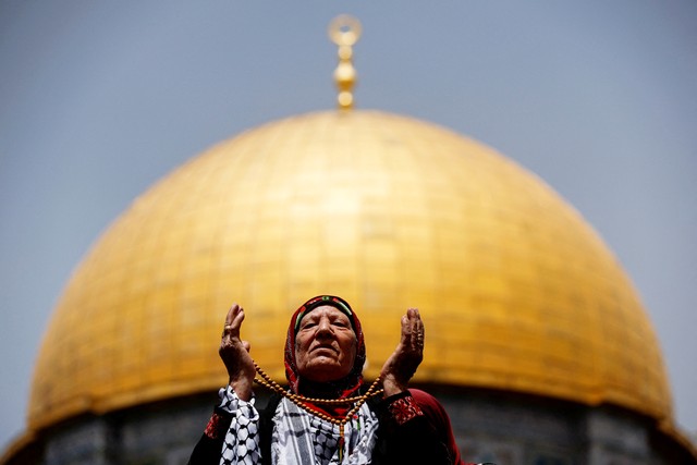 Wanita Muslim berdoa pada Jumat terakhir Ramadhan di depan Dome of the Rock (Kubah Batu), di kompleks Masjid Al-Aqsa di Kota Tua Yerusalem, Jumat (29/4/2022). Foto: Ammar Awad/REUTERS