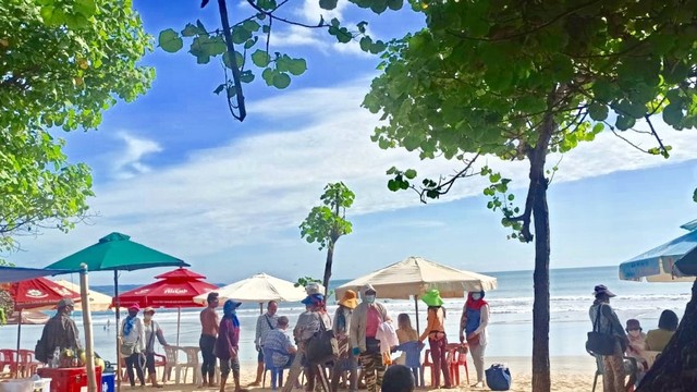 Para pedagang acung yang mengerumuni wisatawan di Pantai Kuta, Bali, Jumat (22/4/2022). Foto: Denita BR Matondang/kumparan