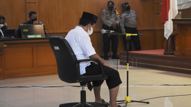 Terpidana kasus kekerasan seksual terhadap anak Herry Wirawan mendengarkan putusan majelis hakim saat menjalani sidang vonis di Pengadilan Negeri Bandung, Jawa Barat, Selasa (15/2/2022). Foto: Rafi Fadh/AP Photo 