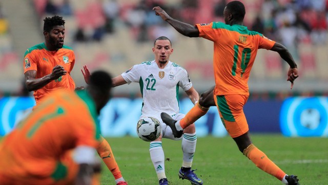 Pemain Aljazair Ismael Bennacer duel dengan Nicolas Pepe dari Pantai Gading saat pertandingan Piala Afrika di Stade de Japoma, Douala, Kamerun, Kamis (20/1/2022). Foto: Thaier Al-Sudani/Reuters
