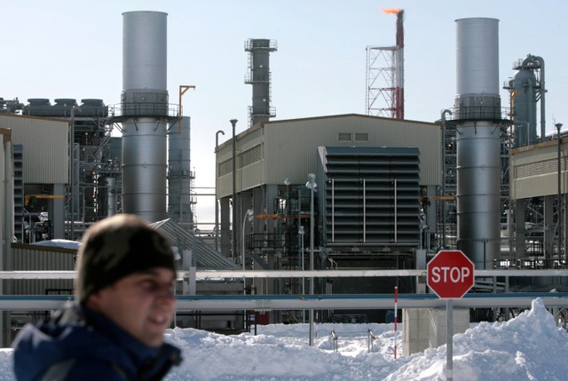 Seorang pria berdiri di luar pabrik gas alam cair (LNG) di Korsakov, Pulau Sakhalin, Rusia pada 17 Februari 2009. Foto: Natalia Kolesnikova/AFP