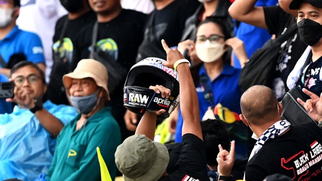 Seorang penonton berhasil menangkap helm yang dilemparkan pembalap Aprilia Racing Aleix Espargaro seusai balapan MotoGP Indonesia di Pertamina Mandalika International Street Circuit, Lombok Tengah, Nusa Tenggara Barat pada Minggu (20/3/2022). Foto: Andika Wahyu/ANTARA FOTO