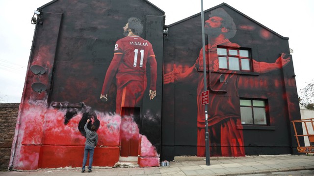 Seniman lokal John Culshaw mengerjakan mural baru pemain sepak bola Liverpool dan Mesir Mohamed Salah di Liverpool, Inggris, 30 Maret 2022. Foto: REUTERS/Phil Noble