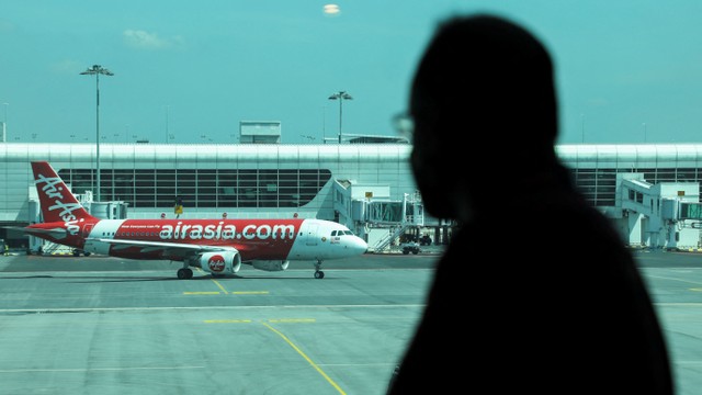 Seorang pria melihat pesawat Air Asia di Bandara Internasional Kuala Lumpur 2 (KLIA2), Sepang, Selangor, Malaysia, (1/4/2022). Foto: Hasnoor Hussain/REUTERS