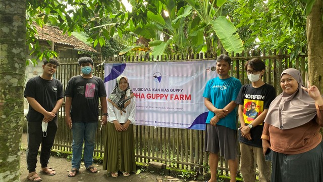 Dokumentasi KKN UMY 271 memberikan kenang kenangan banner kepada Pak Hari