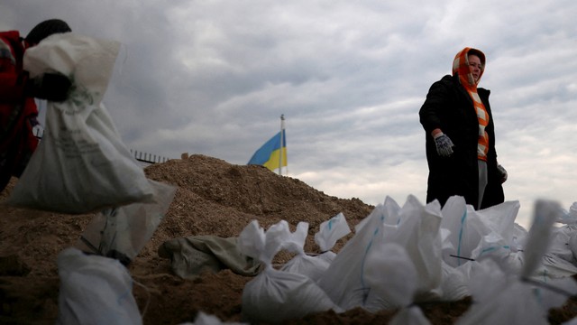 Penduduk setempat membawa karung berisi pasir dari pantai Sobachyy, untuk memperkuat pertahanan kota, di Odessa, Ukraina, Senin (14/3/2022). Foto: Nacho Doce/REUTERS
