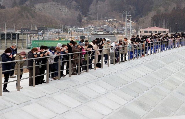 Sejumlah warga Jepang mengheningkan cipta untuk para korban insiden gempa bumi dan tsunami 2011, di Miyako, Prefektur Iwate, Jepang pada Jumat (11/3/2022).
 Foto: STR/JIJI PRESS/AFP