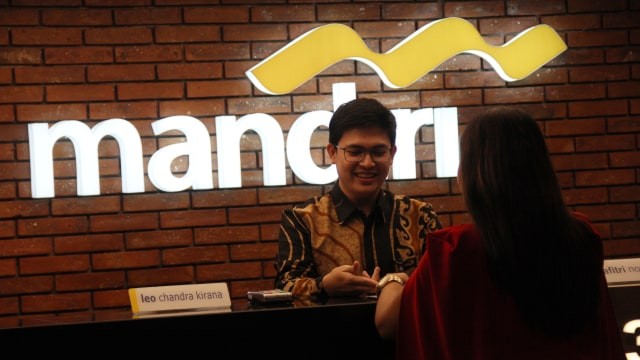 Petugas Bank Mandiri di Mal Senayan City, Jakarta Selatan, melayani nasabah, pada Rabu (11/3). Foto: Jamal Ramadhan/Kumparan